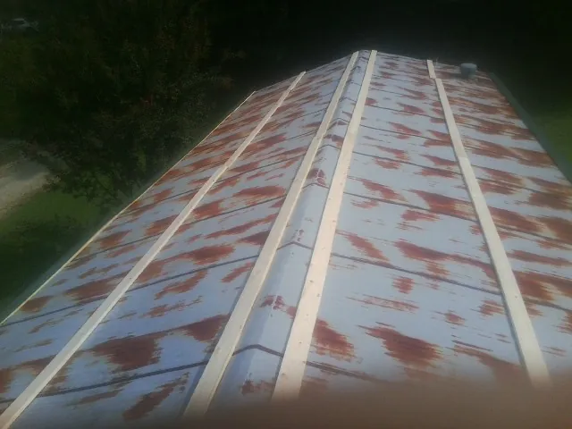 Rusted metal roof panels with new wood purlins before replacement — Storm Damage Roof Repair in Allenton by Roofing Brothers