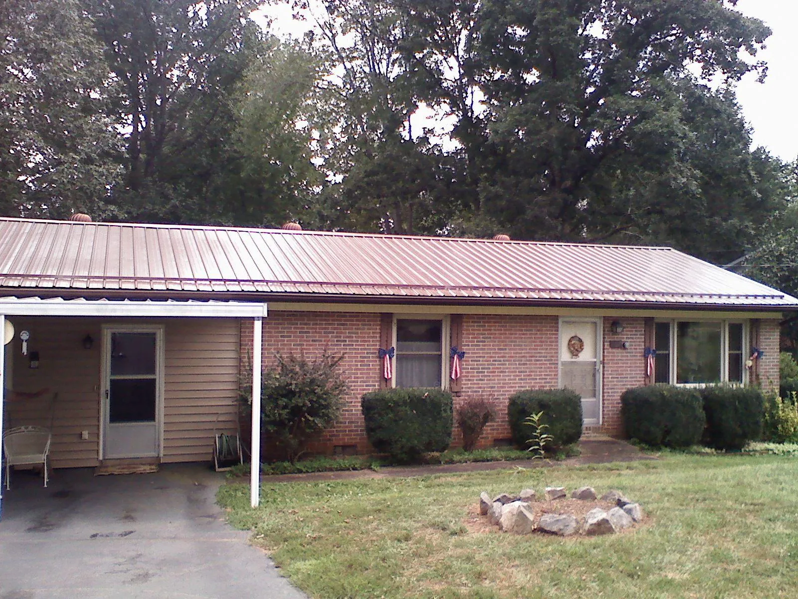 Bronze metal roof and carport on a brick ranch home — Roof Repair work by our crew in Allenton